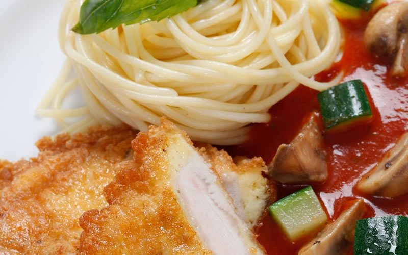 Putenmedaillons in Ei-Käse-Hülle mit Tomaten-Gemüse-Sauce und Spaghetti
